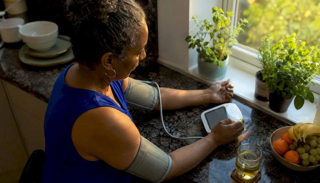 Woman measuring blood pressure at kitchen table